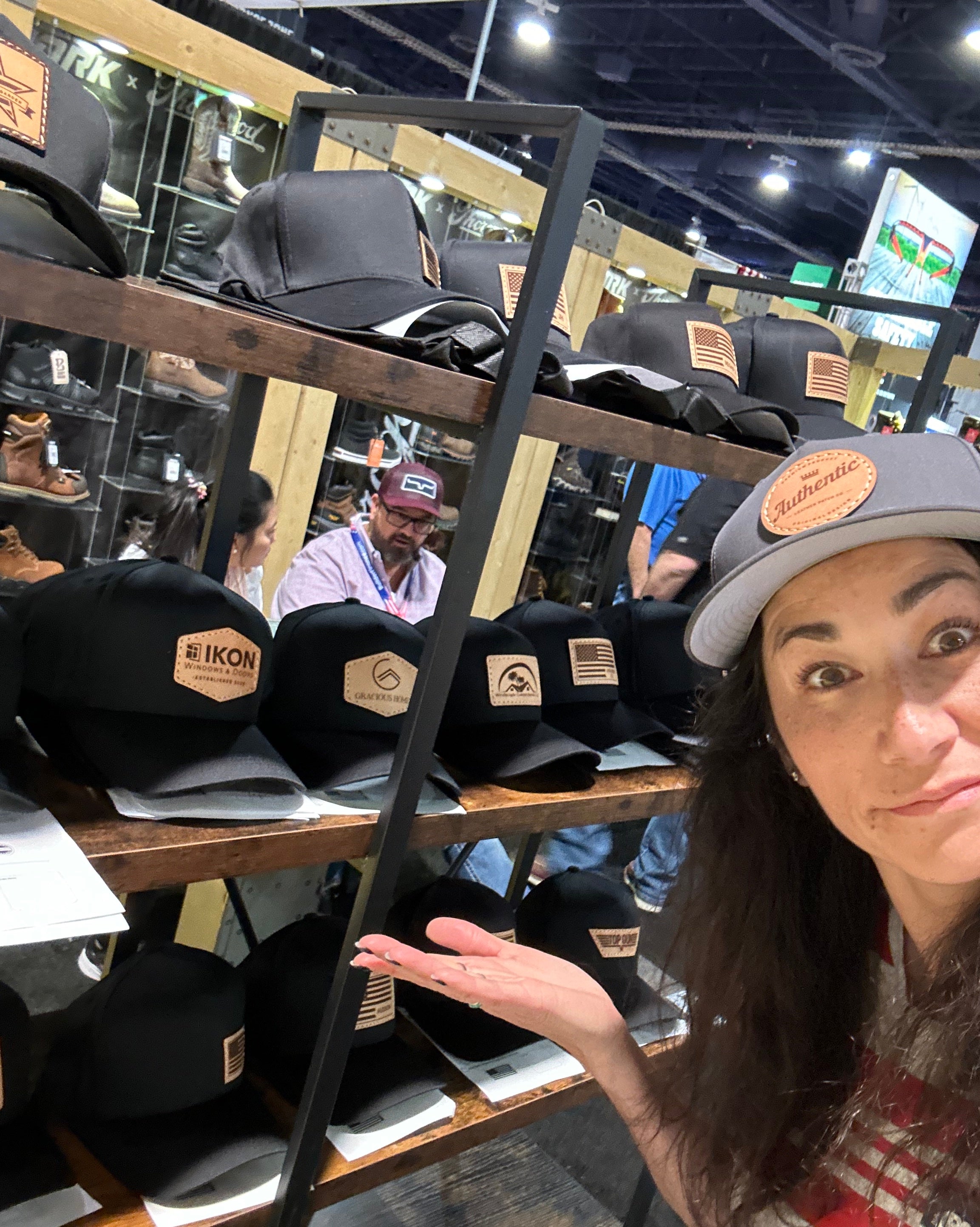 Women showing us the custom leather patch hats we made on the spot at the International Builders Expo