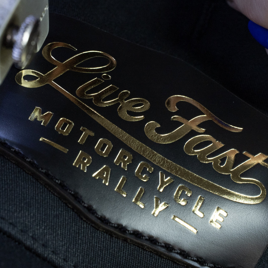 Gold foil live fast rally patch getting stitched onto hat