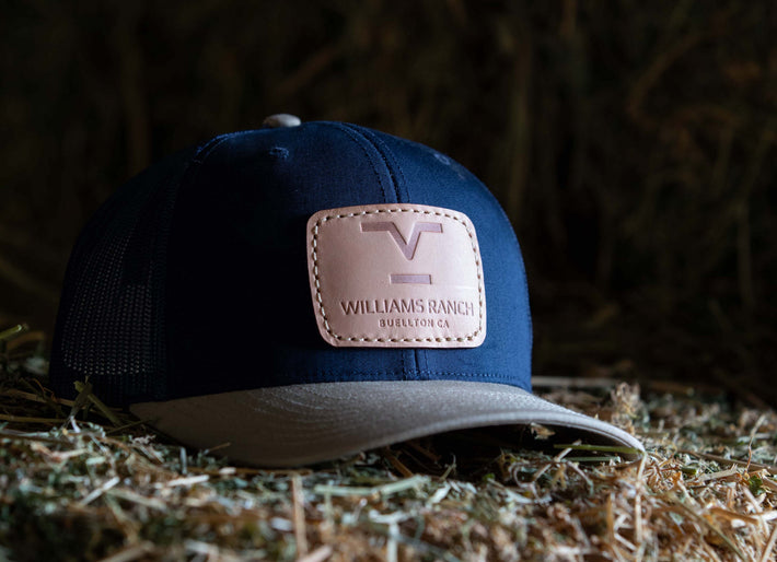 Williams Ranch Branded leather patch hat sitting on hay bales
